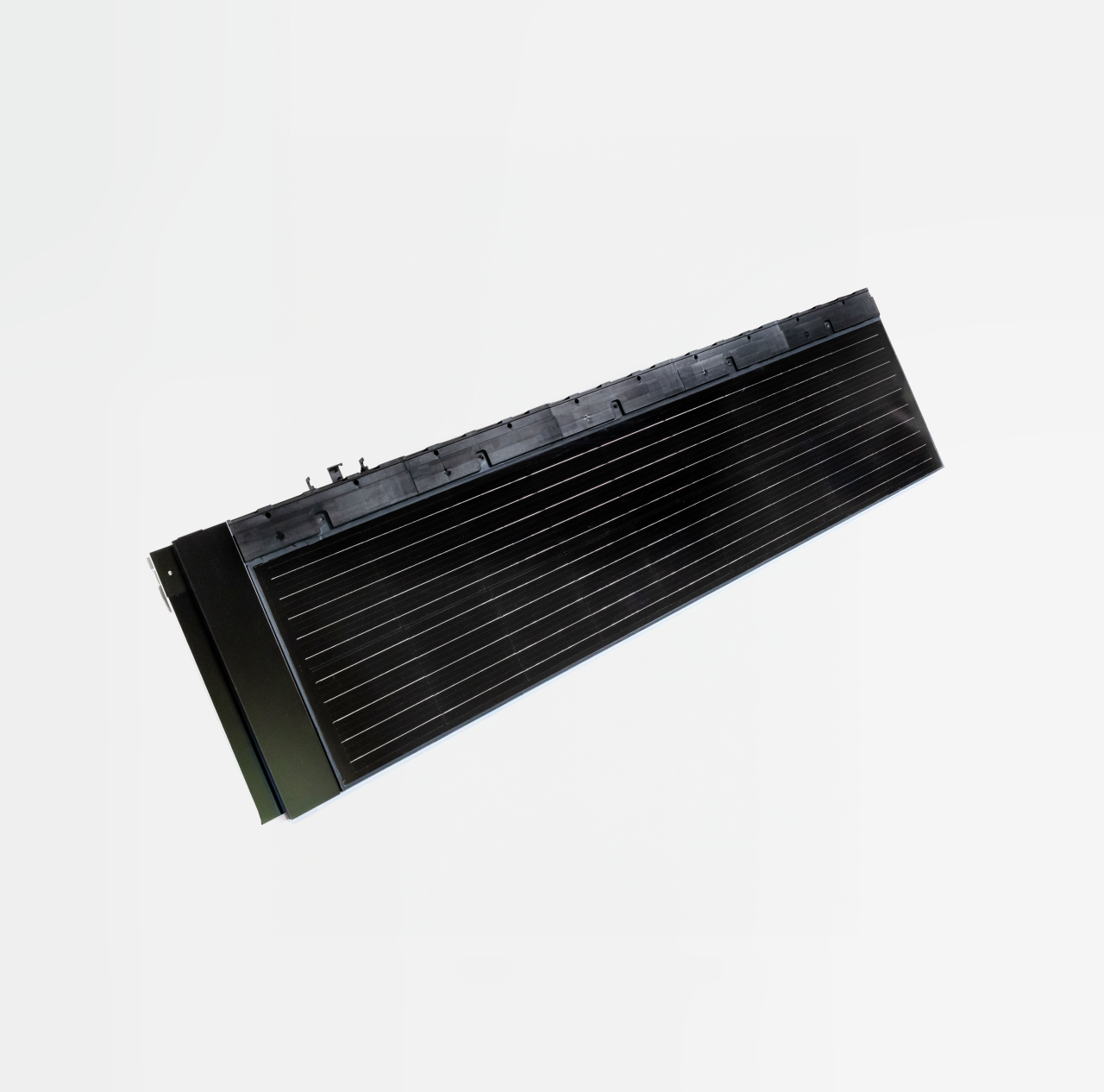 Schwarzes Solarpanel schraeg auf weissem Hintergrund