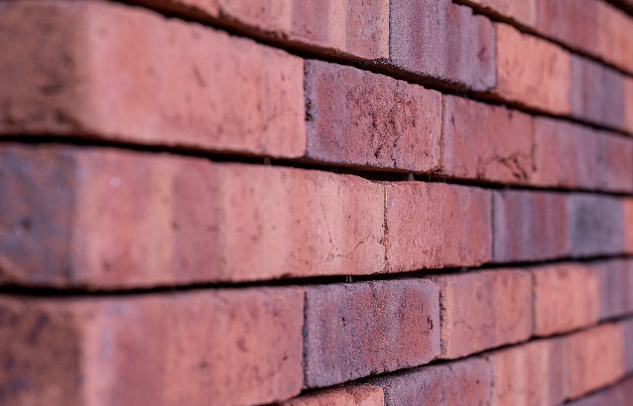 Rote Backsteinmauer aus der Nähe, flache Perspektive