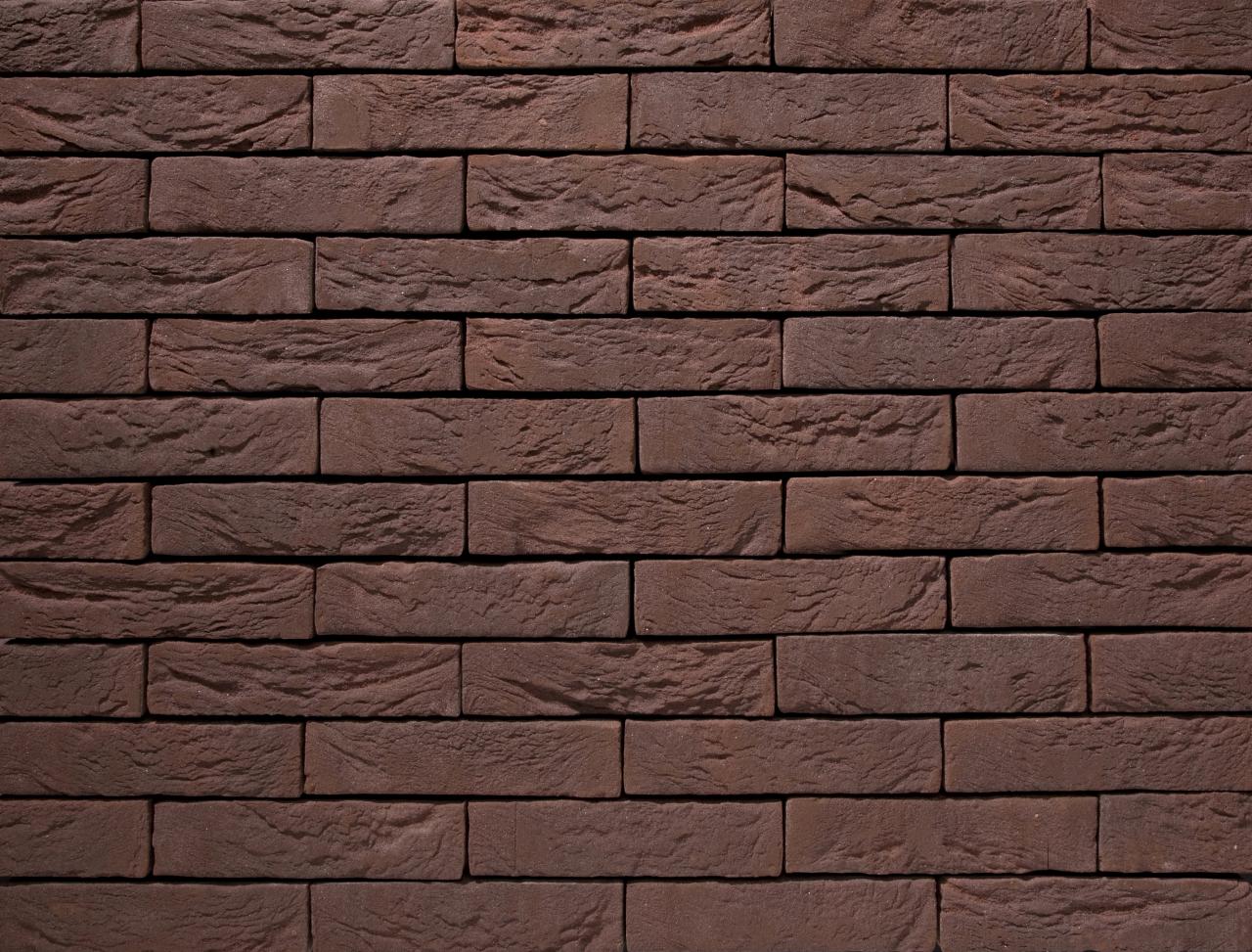 Braune Backsteinmauer mit gleichmaessig angeordneten Steinen