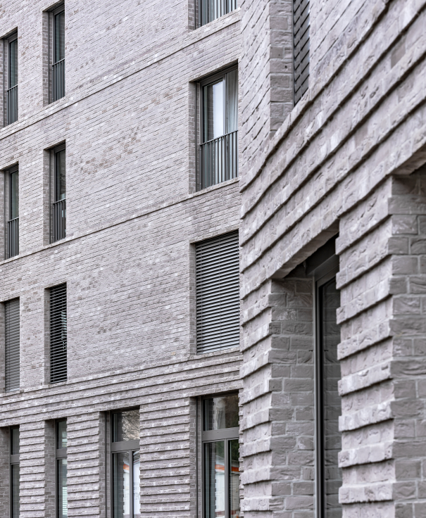 Moderne Fassade aus grauem Backstein mit mehreren Fenstern