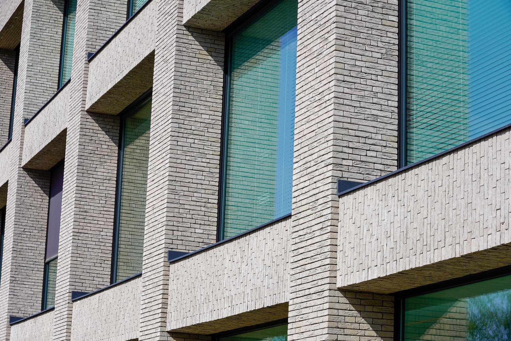 Moderne Fassade mit rechteckigen Fenstern und hellen Klinkersteinen